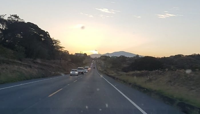 Roads in Central America: Ruta 27 in Costa Rica (with ash plume from volcano in background) 